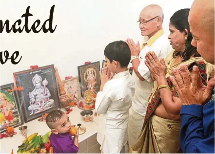  ??  ?? Leong (third from right) is a Hindu and leads his family in offering prayers at home and in the temple.