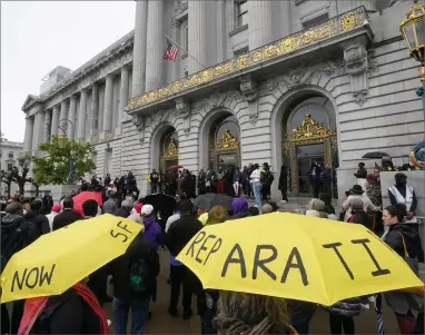  ?? AP PHOTO BY JEFF CHIU ?? A crowd listens to speakers at a reparation­s rally outside of City Hall in San Francisco, Tuesday, March 14, 2023. Supervisor­s in San Francisco are taking up a draft reparation­s proposal that includes a $5 million lump-sum payment for every eligible Black person.