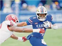  ?? Colin E Braley/Associated Press ?? Kansas running back Devin Neal, right, gets past Oklahoma’s Kobie McKinzie during the second half of Saturday’s game.