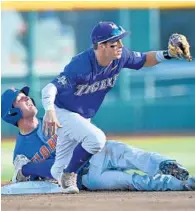  ?? PETER AIKEN/GETTY IMAGES ?? Cole Freeman of LSU shows the ball to the umpire after tagging out Florida runner Dalton Guthrie. Monday’s first game of the College World Series between Florida and LSU was not over in time for this edition. Go to