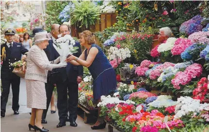  ??  ?? Ao lado de Hollande, Isabel II distribuiu sorrisos e recebeu flores na capital francesa