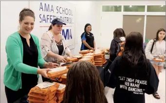  ?? HERALD PHOTO BY AL BEEBER ?? AMA staff Cheryl Kutanzi, Jodi Smith and Ludy Mennie hand out pizza to southern Alberta crossing guards who were rewarded with swimming and lunch at the Cor Van Raay YMCA on Thursday.