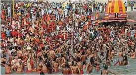  ?? AFP ?? Surging numbers: Hindu holy men celebrate in the river Ganges yesterday