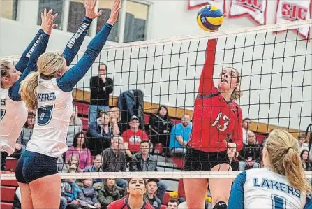  ?? BROCK UNIVERSITY ?? Brock's Tori Carroll (13) is defended by Nipissing in women's university volleyball.