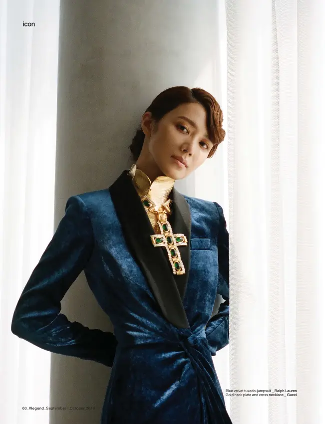  ??  ?? Blue velvet tuxedo-jumpsuit _ Ralph Lauren
Gold neck plate and cross necklace _ Gucci