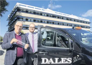  ??  ?? ● Police and Crime commission­er North Wales Arfon Jones and PC Mike Taggart with the White Ribbon sticker for the campaign