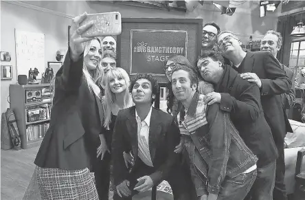  ??  ?? Kaley Cuoco, left, takes a group photo of “The Big Bang Theory” cast and producers just after Warner Bros. dedicated the Burbank soundstage to the top-rated CBS comedy, which finishes its 12-season run in May. WARNER BROS.