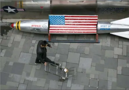  ?? NG HAN GUAN — THE ASSOCIATED PRESS ?? A delivery man with a lone parcel walks past a U.S. apparel store in Beijing Friday.