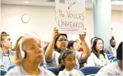  ?? COURTESY OF INNOVATE PUBLIC SCHOOLS ?? Adelita Gomez, a supporter of Promise Academy, holds a sign at a meeting of the San Jose Unified board.