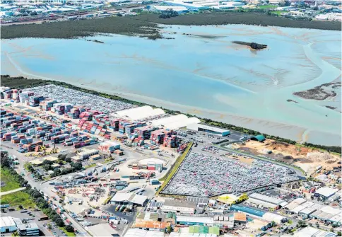  ??  ?? The Onehunga property borders Manukau Harbour and encompasse­s two big car parking areas, four white buildings and vacant land with other buildings at right.