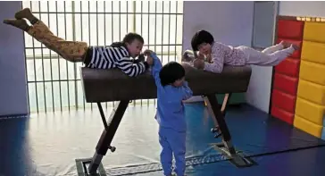  ?? — AFP ?? Gruelling: young gymnasts train at the li Xiaoshuang Gymnastics school in Xiantao, hubei province.