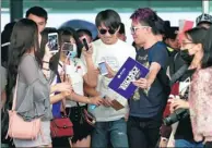  ?? PROVIDED TO CHINA DAILY ?? Dimash Kudaiberge­nov, a popular Kazakh singer, is surrounded by Chinese fans taking photos of him at Guangzhou Baiyun Internatio­nal Airport in Guangdong province last month.