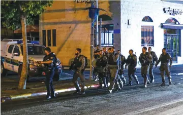  ?? (Flash90) ?? A BORDER POLICE patrol walks the streets of Jaffa on Saturday after riots broke out over the shooting death of an Arab resident by police.