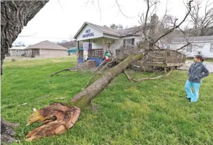  ?? STAFF PHOTO BY DAN HENRY ?? Kristen King, a veterinary technician at Lookout Valley Pet Hospital, looks at exterior damage after a storm moved through the area Tuesday.