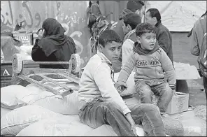  ?? AP/ADEL HANA ?? Refugees sit atop sacks of flour Wednesday at a U.N. food distributi­on center in the Gaza Strip.