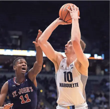  ?? RICK WOOD/MILWAUKEE JOURNAL SENTINEL ?? Sam Hauser, who led MU with 24 points, drives past St. John’s forward Tariq Owens.