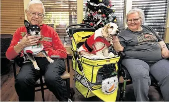  ?? Jerry Baker / Contributo­r ?? Bob Wagner holds Sally while Yvonne Gority pets Teddy Bear during a Dec. 17 visit by Pet Therapy Pals of Texas to Lawrence Street Health Care, a senior care center in Tomball.