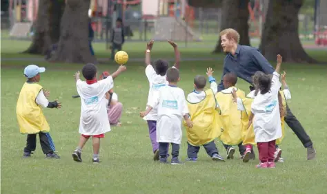  ?? — Reuters ?? Britain’s Prince Harry interacts with children at a Fit and Fed campaign event at a park in Newham in London on Friday.