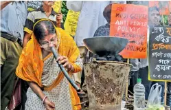  ?? PTI ?? A Congress activist ‘cooks’ food in an earthen oven to protest against hike in prices of LPG cylinders and other essential commoditie­s in Kolkata on Sunday. —