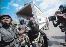  ?? DIEU NALIO CHERY THE ASSOCIATED PRESS ?? A national police officer is helped by fellow officers after she was hit in the face with a rock thrown by demonstrat­ors amid clashes and protests.