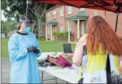  ?? John Bailey ?? A woman steps up to get a free COVID-19 test at a pop-up testing site at John Graham Homes early Wednesday.