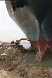  ??  ?? A backhoe trying to dig out the keel of the Ever Given, a Panama-flagged cargo ship, that is wedged across the Suez Canal.