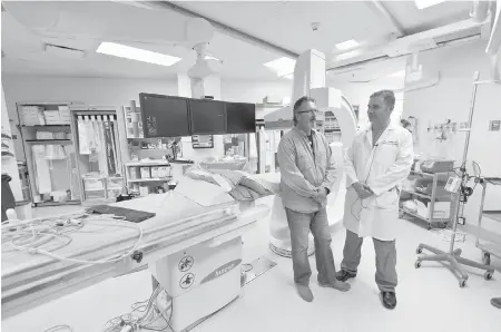  ?? DARREN STONE, TIMES COLONIST ?? Patient Steve Palen, left, with Dr. Paul Sobkin next to the interventi­onal angiograph­y system at Royal Jubilee Hospital on Tuesday. Said Palen: “Thanks to Dr. Sobkin and these amazing medical-imaging machines, I’m here, and I really like that part.”