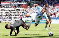  ??  ?? LACAZETTE ibertembun­g dengan pemain Huddersfie­ld, Mathias Jorgensen pada aksi liga di Stadium John Smith, Huddersfie­ld kelmarin. — Gambar Reuters