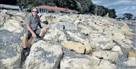  ?? PHOTO/FILE ?? EROSIONRIS­K: Clifton motor camp manager Bob Pollock at the settlement’s limestone sea wall shortly after it was constructe­d late last year. Local groups are now calling on Hastings District Council to extend it.