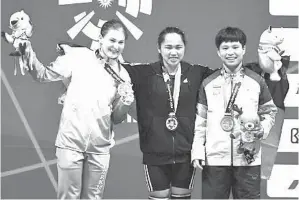  ??  ?? The Weightlift­ing Women’s 53- kg 2018 Asian Games champion (center) with silver medalist Kristina Shermetova of Turkmenist­an ( left) and bronze medalist Surodchana Khambao of Thailand (right).