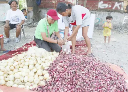  ?? PHOTOGRAPH BY JOEY SANCHEZ MENDOZA FOR THE DAILY TRIBUNE @tribunephl_joey ?? WHITE and red onions are being sold along the sidewalk of Tirona Highway in Bacoor, Cavite on Sunday morning. The onions are sold at P50 per kilo.