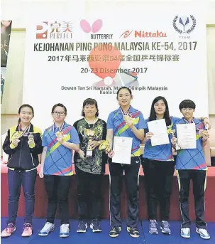  ??  ?? CEMERLANG: Pemain wanita Sarawak bergambar kenangan bersama jurulatih, Chua Yeo Fong (tiga kiri) selepas menerima hadiah.