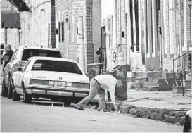  ?? KENNETH K. LAM/ BALTIMORE SUN ?? A Baltimore police officer collects evidence at a shooting scene on March 30, 2020, in which officers shot and killed a man they said was armed. More than a year passed before prosecutor­s made public their report on what happened.