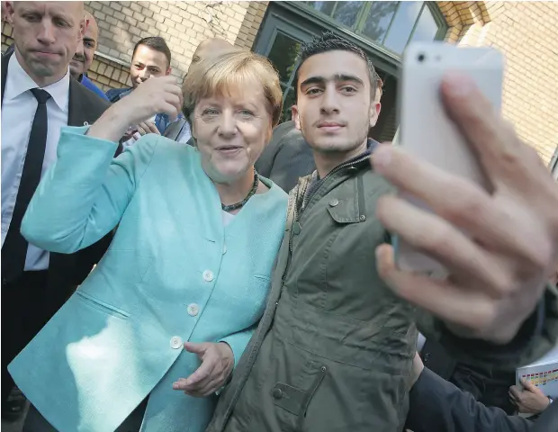  ?? SEAN GALLUP / GETTY IMAGES FILES ?? German Chancellor Angela Merkel poses for a selfie with Anas Modamani, a migrant from Syria, in September 2015 in Berlin, Germany. Since that innocuous photo was taken, Modamani has become a target of false terrorist allegation­s and other far-right...