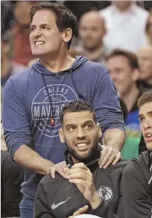  ?? STAFF PHOTO BY MATT STONE ?? SQUEEZE PLAY: Outspoken Mavericks owner Mark Cuban and center Salah Mejri react to a play as they watch last night’s game at the Garden.