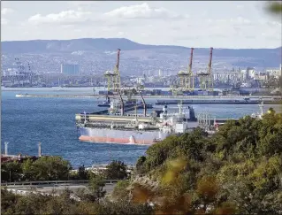  ?? AP 2022 ?? An oil tanker is moored last October at the Sheskharis complex in Novorossiy­sk, Russia, one of the largest facilities for oil and petroleum products in southern Russia. Russia has lost some $100 billion in oil revenue after an EU import ban and a $60-per-barrel price cap imposed by the Group of Seven, which bars Western insurers and shippers from handling oil priced above that level. Russia has increasing­ly found ways around the cap, including using a fleet of ghost tankers masking their ownership and origin of the crude they carry.