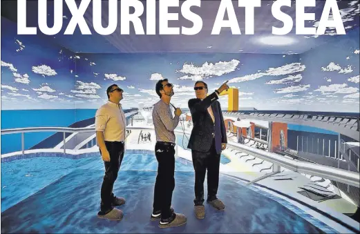  ?? PHOTOS by PATRICK FARRELL/MIAMI HERALD ?? Wearing 3-D glasses, Richard Fain, chairman of Royal Caribbean Cruises Limited, right, chats with architects Paul Moreira, left, and Tom Wright inside the company’s new Innovation Center. The virtual cruise ship allows them to fine-tune new features.