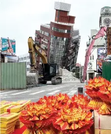  ?? Photo — AFP ?? Photo released by Taiwan’s Central News Agency (CNA) shows paper money, organised by Hualien government, being placed on a table as offering before demolishin­g the Uranus building following an earthquake in Hualien.