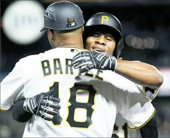 ?? Matt Freed/Post-Gazette ?? Gift Ngoepe hugs first base coach Kimera Bartee after getting his first major league hit in the fourth inning Wednesday night at PNC Park.