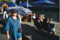  ?? (File Photo/ap/francois Mori) ?? A woman shelters from the sun with an umbrella Aug. 2, 2022, along the Seine River in Paris, France.