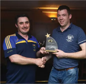  ??  ?? Wicklow County team manager John Clarke presents the Player of the Year trophy to Wicklow and Parkview team member Mark Collins.