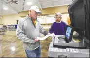  ?? NWA Democrat-Gazette/FLIP PUTTHOFF ?? Derek Gray casts his ballot Tuesday at Lakeview Church in Cave Springs with poll worker Brenda Taylor.