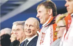  ??  ?? This file photo taken on February 23, 2014 shows Russian President Vladimir Putin (centre) standing next to Alexander Zubkov, gold medallist in the two-man and four-man bobsleigh for Russia, during the Closing Ceremony of the 2014 Sochi Winter Olympics...