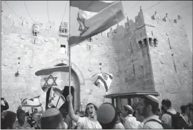  ?? Ariel Schalit/AP ?? Embassy: Israelis wave national flags outside the Old City's Damascus Gate, in Jerusalem Sunday. Israel is marking the 51st anniversar­y of its capture of east Jerusalem in the 1967 Middle East war.