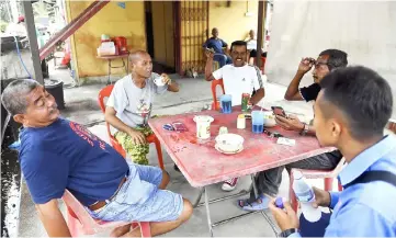  ??  ?? Villagers at Kampung Parit, Negeri Sembilan sitting at Kopitiam Kampong Parit enjoying their breakfast.