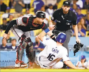  ?? Photograph­s by Allen J. Schaben Los Angeles Times ?? THE DODGERS’ Will Smith is tagged out by Diamondbac­ks catcher Carson Kelly in the eighth inning after Smith tried to score on Gavin Lux’s single to right field. The Dodgers prevailed 5-2 for win No. 102 this season.