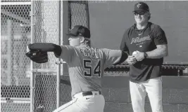  ?? JORDAN MCPHERSON ?? Marlins pitching coach Mel Stottlemyr­e Jr. watches as prospect Nic Enright throws a bullpen session last week. Enright is being treated for Stage 2 Hodgkin lymphoma.