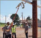  ?? Contribute­d photo ?? Practicing on equipment that is not energized, students use insulated fiberglass “hot sticks” to simulate operating a high-voltage fuse assembly.