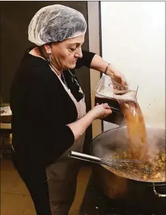  ?? Arnold Gold / Hearst Connecticu­t Media ?? Giuliana Maravalle adds chicken stock to chicken marsala at Nonna Gina's Prepared Foods and Gelateria in Branford on Thursday.