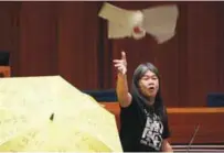  ?? REUTERSPIX ?? Re-elected lawmaker Leung Kwok-hung throws a torn placard while taking oath at the Legislativ­e Council yesterday.